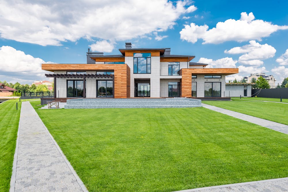 Exterior of modern mansions with glass doors and panoramic windows.